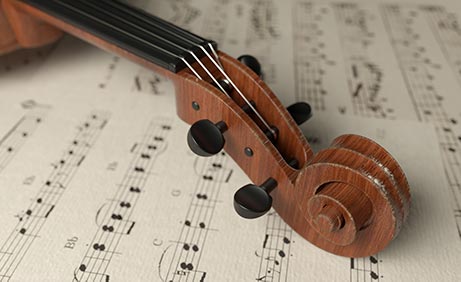 Hölzerner Violinenhals liegt auf einem Stapel Notenblätter